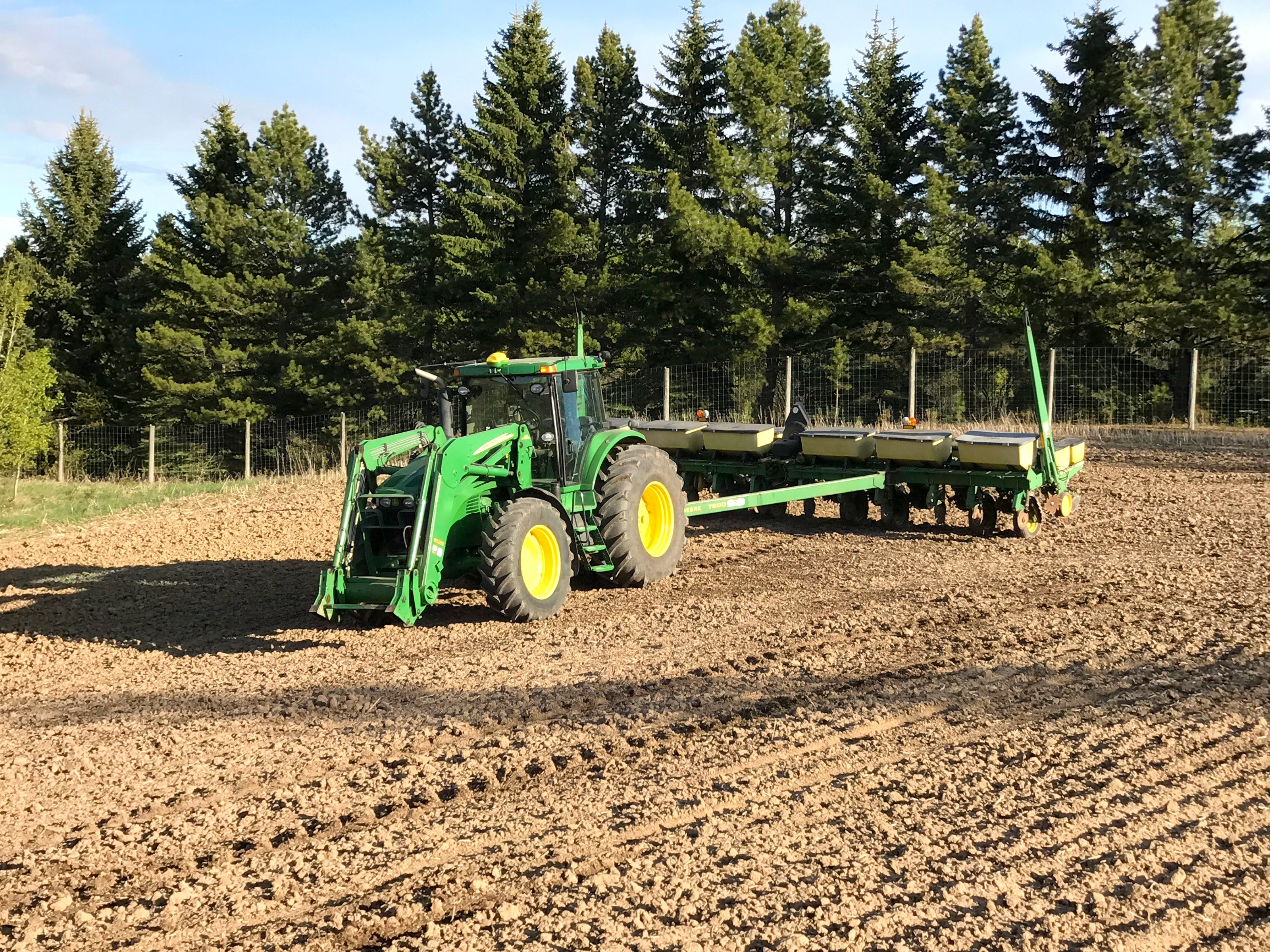 A John Deere tractor and planter in spring