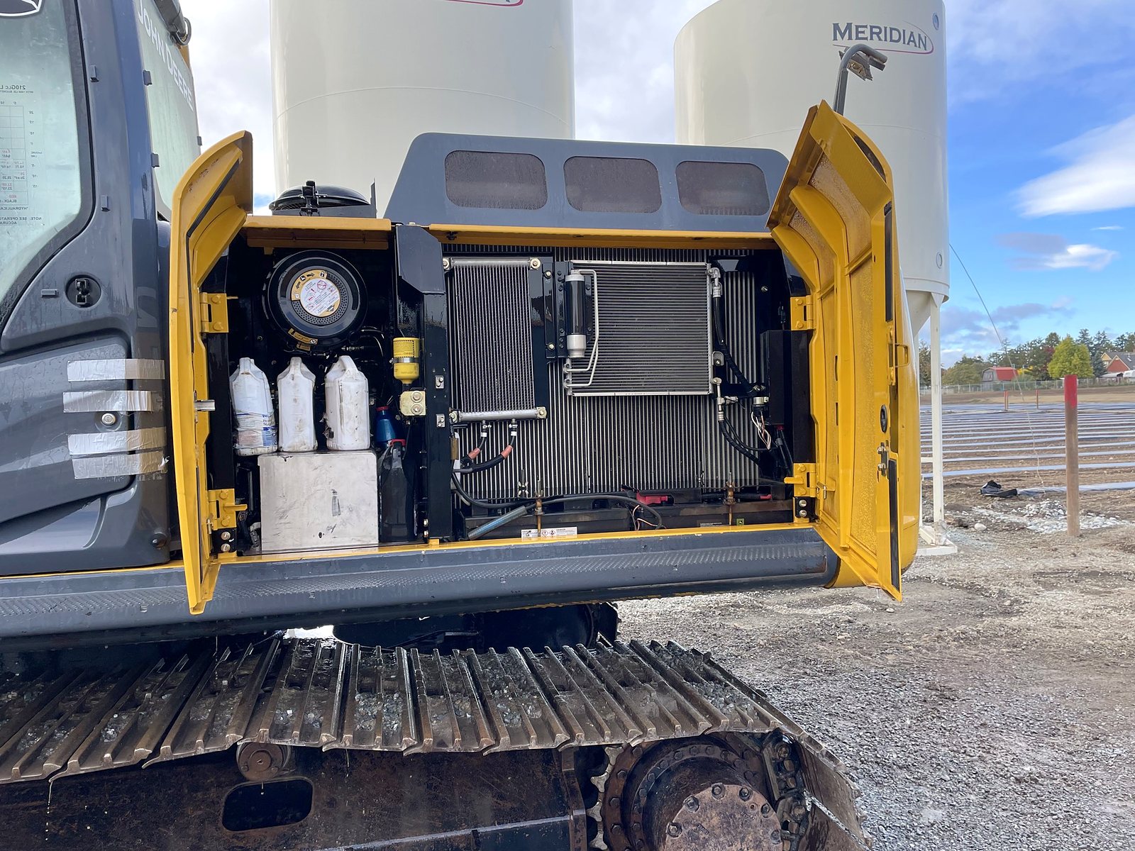 De John Deere 210G vun der Grupp mat opener Motorhaub