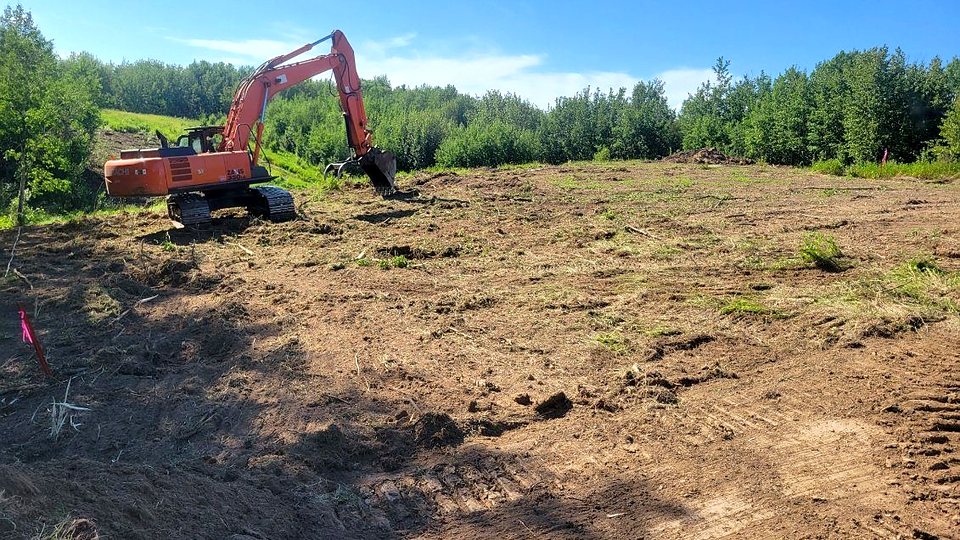 The group's Hitachi excavator working a cleared slope, bucket down