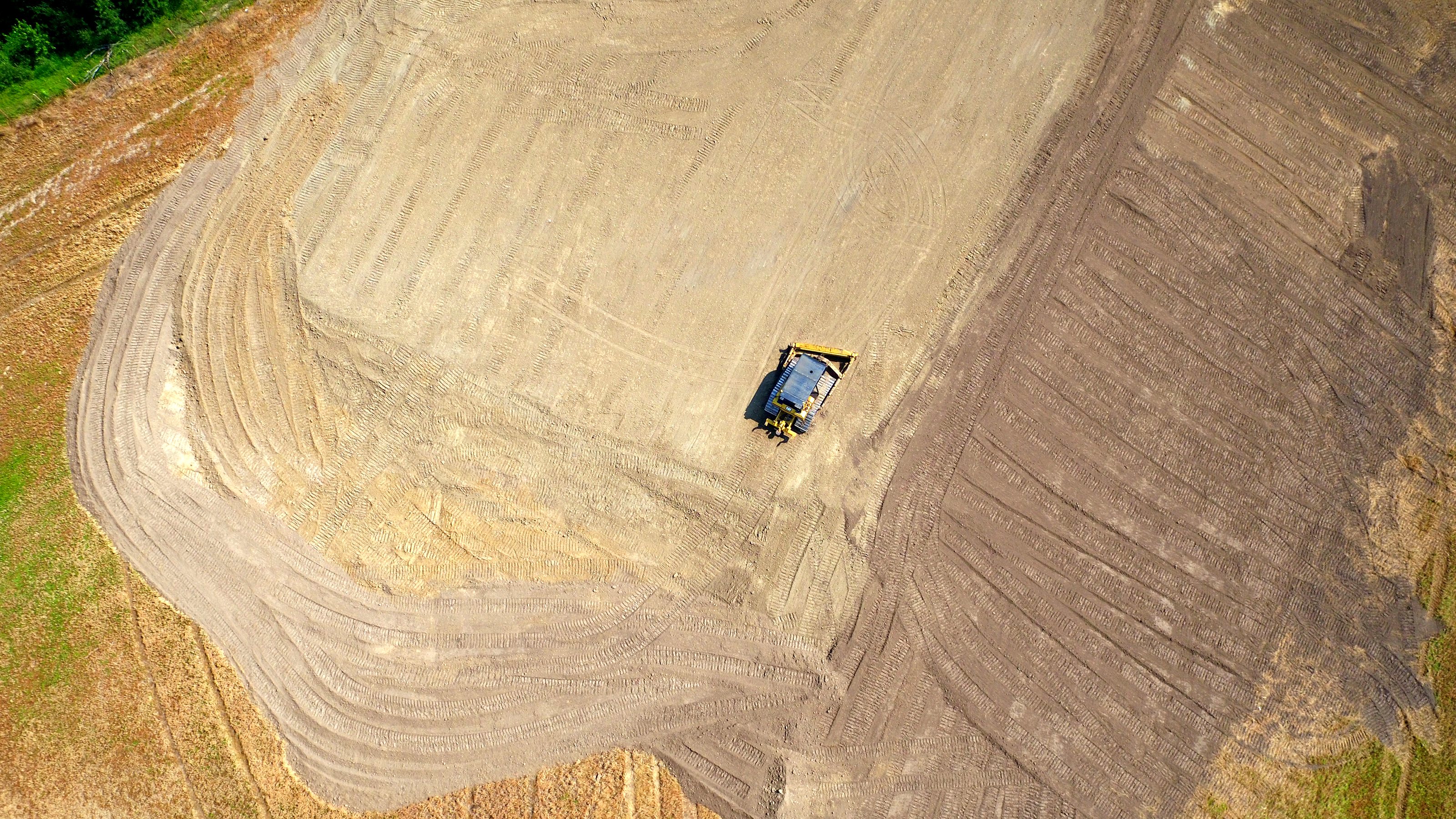 A machine grading a field, from the air